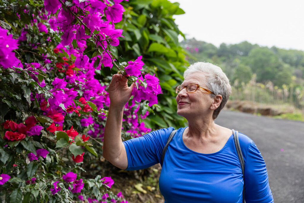 Elder Care Alliance resident enjoying a walk and smelling the flowers